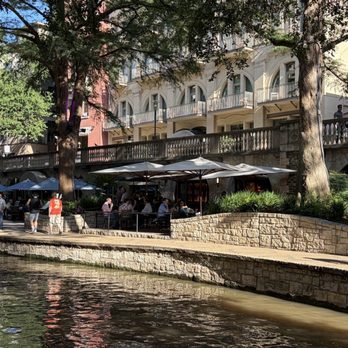 Shaded riverside patio seating along the San Antonio River Walk outside Iron Cactus